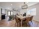 Staged dining room boasts modern light fixture, wood floors, and stylish seating, flowing into the spacious living room at 4234 E Winnetka Dr, Phoenix, AZ 85044
