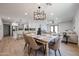 Open-concept dining area features wood flooring, modern lighting, and seamless flow to the kitchen and living spaces at 4234 E Winnetka Dr, Phoenix, AZ 85044