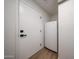 Hallway featuring a white door and a compact refrigerator, offering additional storage options at 4234 E Winnetka Dr, Phoenix, AZ 85044