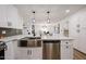 Bright, remodeled kitchen features stainless appliances, white cabinets, quartz countertop island, and modern fixtures at 4234 E Winnetka Dr, Phoenix, AZ 85044