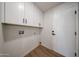 Bright laundry area with white cabinets and wood-look floors, offering storage and functionality at 4234 E Winnetka Dr, Phoenix, AZ 85044