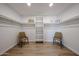 Spacious walk-in closet with built-in shelving and ample storage space and two chairs at 4234 E Winnetka Dr, Phoenix, AZ 85044