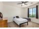 Bright bedroom with a ceiling fan, grey curtains, and a window with neutral carpet at 44157 W Palo Amarillo Rd, Maricopa, AZ 85138