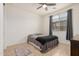 Neutral bedroom with a ceiling fan, grey curtains, and a window with brown tile flooring at 44157 W Palo Amarillo Rd, Maricopa, AZ 85138