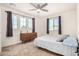 Comfortable bedroom with a large window, grey curtains, and a wooden dresser with neutral carpet at 44157 W Palo Amarillo Rd, Maricopa, AZ 85138