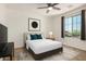 Bright bedroom with a ceiling fan, window, and carpet, complete with white linens and green pillows at 44157 W Palo Amarillo Rd, Maricopa, AZ 85138