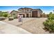 Two-story home featuring three-car garage, desert landscaping, and concrete driveway at 44157 W Palo Amarillo Rd, Maricopa, AZ 85138