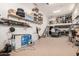 Large garage with ample shelving, storage, a fan, and stairs to a mezzanine, perfect for organization at 44157 W Palo Amarillo Rd, Maricopa, AZ 85138