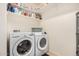 Well-organized laundry room features white front load washer and dryer and ample shelving for storage at 44157 W Palo Amarillo Rd, Maricopa, AZ 85138