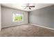 Neutral bedroom with carpet, a ceiling fan, and a large window providing natural light at 4434 E Bannock St, Phoenix, AZ 85044