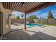 Outdoor oasis featuring a sparkling pool, covered patio, and lush landscaping for relaxing and entertaining at 4434 E Bannock St, Phoenix, AZ 85044