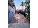 An outdoor tiled patio area with a palm tree, plants, and fencing at 4644 W Berridge Ln, Glendale, AZ 85301