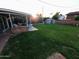 Lush backyard featuring a covered patio area with green lawn at 4644 W Berridge Ln, Glendale, AZ 85301