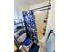 A compact bathroom featuring a shower with modern fixtures and vanity storage at 4644 W Berridge Ln, Glendale, AZ 85301