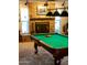 Pool table highlighted in a game room with a brick fireplace, windows, and unique lighting fixtures at 4644 W Berridge Ln, Glendale, AZ 85301
