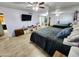 Main bedroom featuring a large bed, mirrored wall, mounted TV, and views to the ensuite bathroom at 4644 W Berridge Ln, Glendale, AZ 85301