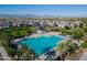 An aerial view shows a sparkling community pool, surrounded by palm trees and well-maintained homes at 5741 W Warner St, Phoenix, AZ 85043