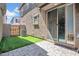 Cozy backyard featuring artificial turf, paver patio, and sliding glass door access to the home's interior at 5741 W Warner St, Phoenix, AZ 85043