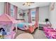 Playful bedroom featuring a bed, toy kitchen, play tent and pink accents at 5741 W Warner St, Phoenix, AZ 85043