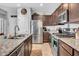 Well-lit kitchen featuring stainless steel appliances, granite countertops, and dark wood cabinetry at 5741 W Warner St, Phoenix, AZ 85043