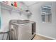 Clean laundry room with a side by side washer and dryer and shelves at 5741 W Warner St, Phoenix, AZ 85043