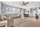 Spacious living room featuring wood-look tile, neutral paint, updated fan and a sectional sofa at 5741 W Warner St, Phoenix, AZ 85043