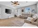 Spacious living room featuring wood-look tile, neutral paint, updated fan and a sectional sofa at 5741 W Warner St, Phoenix, AZ 85043