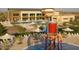 Aerial view of the community pool area with lounge chairs, umbrellas, and a fun splash zone for  at 6354 W Rushmore Way, Florence, AZ 85132