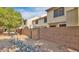 A backyard features a block wall, rocks, and trees creating a private and natural outdoor space at 921 W University Dr # 1191, Mesa, AZ 85201