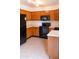 An efficiently designed kitchen, featuring wood cabinetry and modern black appliances for a sleek look at 921 W University Dr # 1191, Mesa, AZ 85201