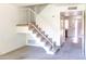 View of the staircase and an entryway featuring neutral carpeting and white railings to the upper level at 921 W University Dr # 1191, Mesa, AZ 85201