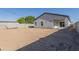 A large backyard with dirt and a block fence, featuring a covered patio at 9310 W Washington St, Tolleson, AZ 85353