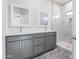 Bathroom featuring dual vanities, each with a mirror and a spacious shower with tile surround at 9310 W Washington St, Tolleson, AZ 85353