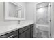Modern bathroom features gray vanity with white countertop and a tub-shower with elegant marble style tile at 9310 W Washington St, Tolleson, AZ 85353