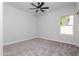 Well-lit bedroom features a ceiling fan, soft carpet, and a window providing a comfortable atmosphere at 9310 W Washington St, Tolleson, AZ 85353