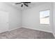 Cozy bedroom with neutral carpet, a ceiling fan, and a window offering natural light, ready for personalization at 9310 W Washington St, Tolleson, AZ 85353