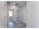 Hallway featuring gray tile floors, white walls and doors, and open doorways to the bedrooms at 9310 W Washington St, Tolleson, AZ 85353