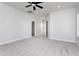 Main bedroom with plush carpeting, a ceiling fan, and easy access to the walk-in closet and bathroom at 9310 W Washington St, Tolleson, AZ 85353