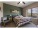 Comfortable bedroom with a cozy bed, olive colored accent wall, ceiling fan and view to the outside at 9750 N Monterey Dr # 71, Fountain Hills, AZ 85268