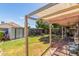 Large backyard featuring a covered patio, lush greenery, and a storage shed at 10465 W Windsor Blvd, Glendale, AZ 85307