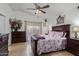 Well-lit bedroom featuring a decorative ceiling fan, warm tile flooring, and matching furniture set at 10465 W Windsor Blvd, Glendale, AZ 85307