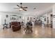 Spacious living room with tiled flooring, ceiling fan, and an open layout connecting to the dining area at 10465 W Windsor Blvd, Glendale, AZ 85307