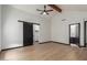 Primary bedroom features wood beam, fan, modern barn door to closet and light wood flooring at 10849 E Elmwood St St, Mesa, AZ 85207