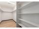 Walk-in closet with white shelving and wood floor at 10849 E Elmwood St St, Mesa, AZ 85207