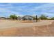 Desert home with gravel circular driveway and desert landscaping with green lawn at 10849 E Elmwood St St, Mesa, AZ 85207