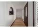 Hallway with wooden floors, archway, and dark trimmed windows and doors at 10849 E Elmwood St St, Mesa, AZ 85207