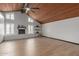 Spacious living room featuring wood floors, white brick fireplace, and wood beamed ceiling with ceiling fan at 10849 E Elmwood St St, Mesa, AZ 85207