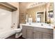 Well-lit bathroom featuring double sinks, vanity, and combined tub and shower at 11807 E Clinton St, Scottsdale, AZ 85259