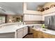 Bright kitchen showcasing white cabinetry, stainless steel appliances, and a functional island prep station at 11807 E Clinton St, Scottsdale, AZ 85259