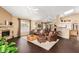Bright and open-concept living room featuring a stone fireplace, and dark hardwood floors at 11807 E Clinton St, Scottsdale, AZ 85259